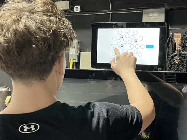 A young athlete touching targets on the Senaptec Sensory Station screen